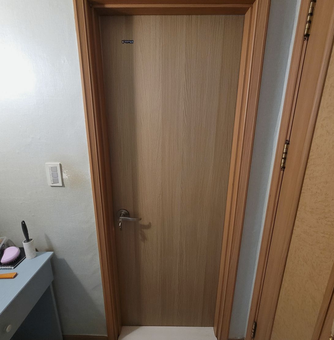 새 문짝으로 교체해 문틀 색과 맞춰 마감한 상태